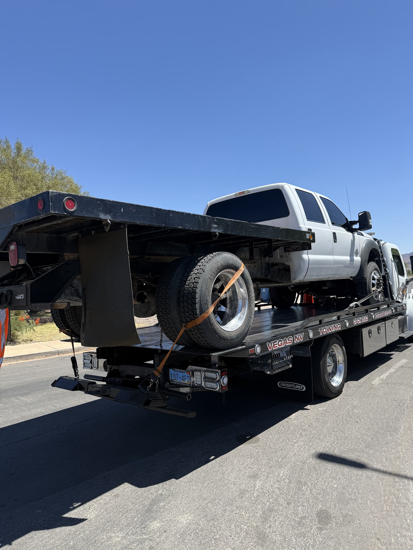White Ford Super Duty dually pickup loaded on a Vegas NV Towing flatbed